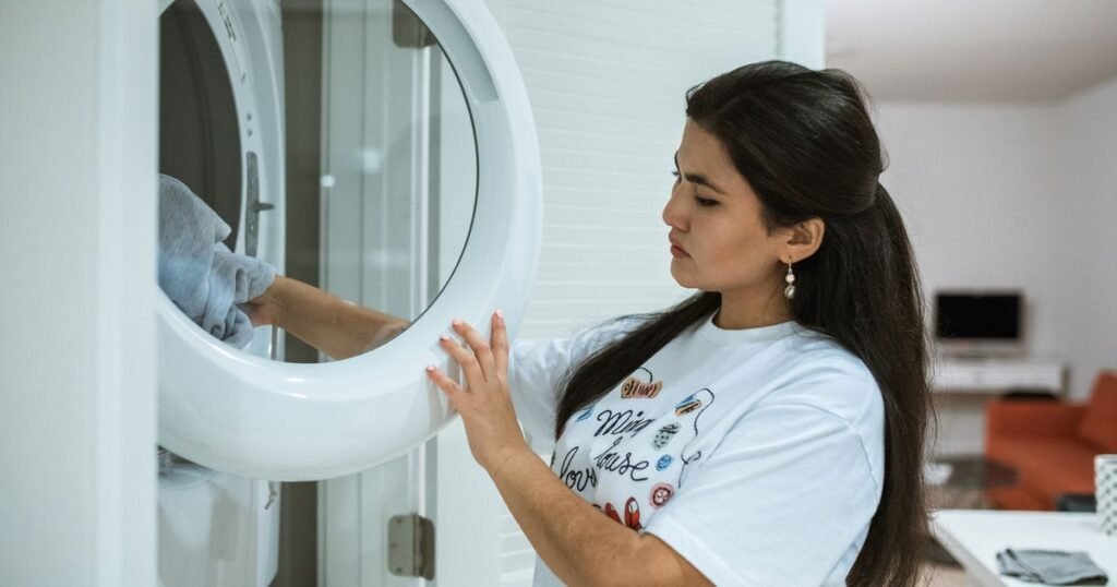 College student loading a washing machine, laundry service for Denver students