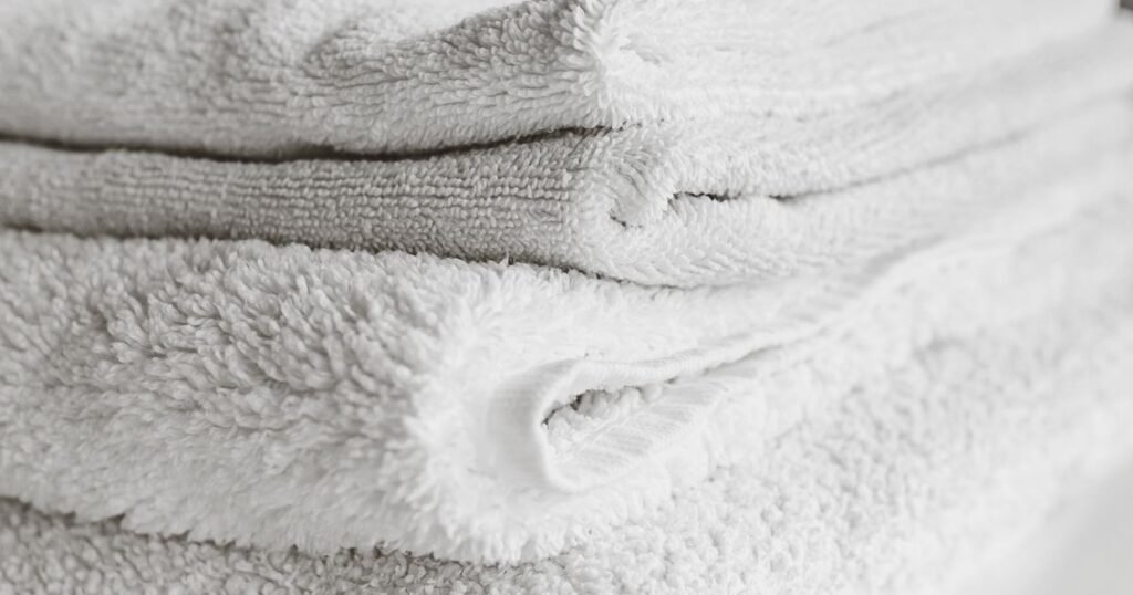 Freshly washed and folded white towels stacked and ready for delivery, Denver wash and fold laundry service